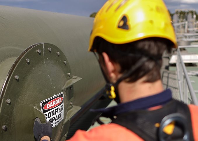An employee opening a vault A worker entering into a Confined Space