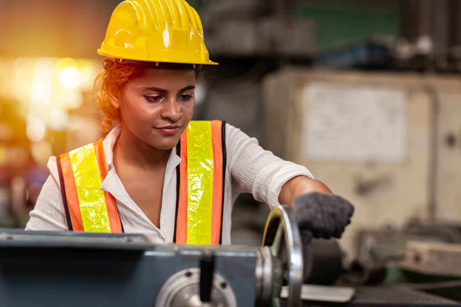 Girl teen worker african american working labor in industry factory with heavy steel machine.