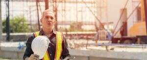 Tired fatigued engineer worker constructor working in construction site.