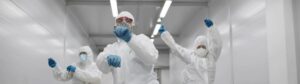 Team of medical workers in hazmat suits dancing and walking in hospital corridor. Funny disinfectors in respiratory mask and protective uniform dancing celebrating end of epidemic