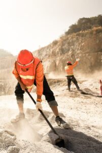 Miners working with mining tool in dusty and baking hot, mining and summer hot sun in the backgrounds. Hard work concept. Noise, Grain.