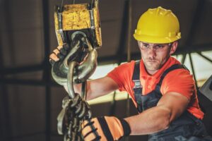 Caucasian Warehouse Lift Operator in His 30s. Heavy Duty Lifting Equipment.