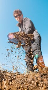 Man digging a hole in the ground with a shovel