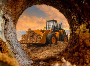 Wheel loader are digging the soil in the tunnel construction site on the sky background