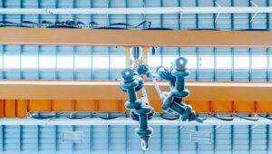 Overhead crane and machine inside factory building, industrial background.