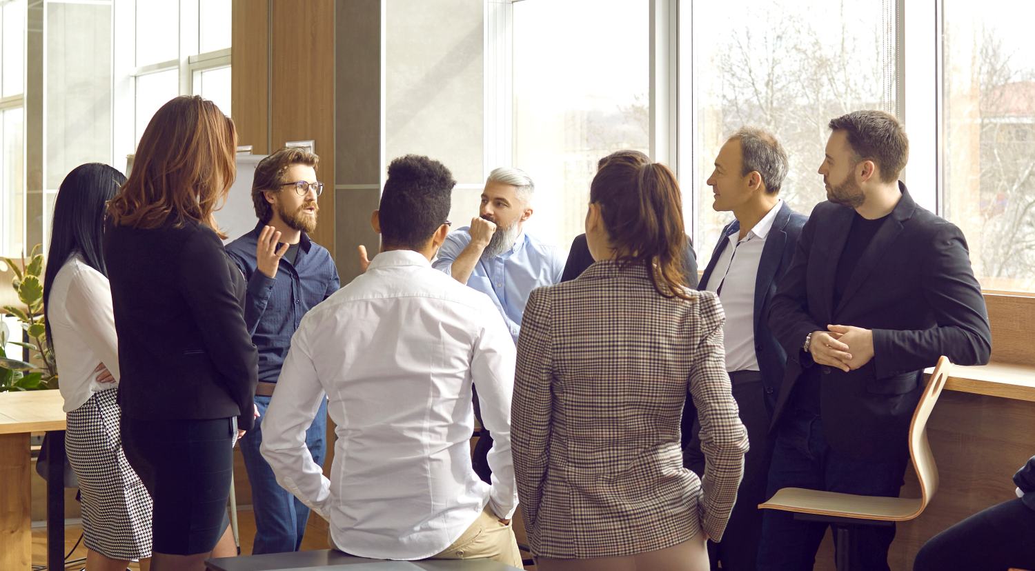 Business coach meeting with group of people in modern office interior. Team of workers listening to teacher's inspirational speech during creative business training class. Banner, header background