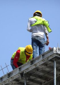 Construction workers working at height without wearing proper sa